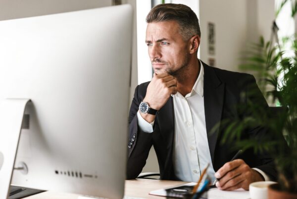 Image of confident businessman working in office and looking on computer